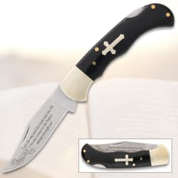 Folding knife with cross inlay and engraved blade on open book