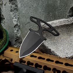 Black Legion Shadow Dagger resting on a textured rock surface