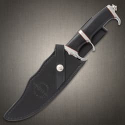 Large knife with black, red, and silver, hilt exposed with the blade enclosed in a black leather sheath stamped with "Hibben Knives" logo
