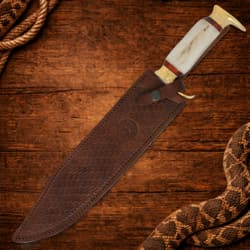 Knife in a brown leather sheath on wooden surface