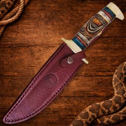 Bowie knife in leather sheath on wooden surface with rope