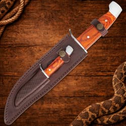 Knife in a leather sheath on a wooden background