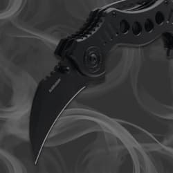 Close-up of a black folding knife blade with smoky background