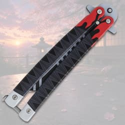 Closed butterfly knife with flame design on a scenic background