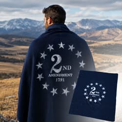 Person with blanket featuring '2nd Amendment 1791' design in mountains