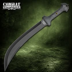 Black tactical knife with a long curved blade and textured handle on a green background