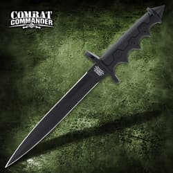 Black dagger with a textured grip on a green surface