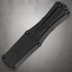 Close-up of black knife handle with clip on gray background