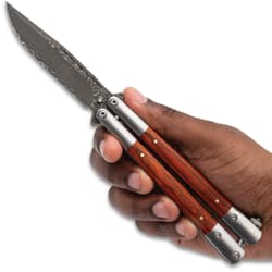 Hand holding an open butterfly knife with wooden handles