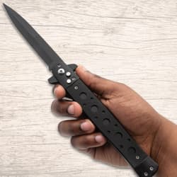 Hand holding a black stiletto knife