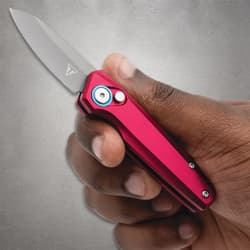 Hand holding a red folding knife