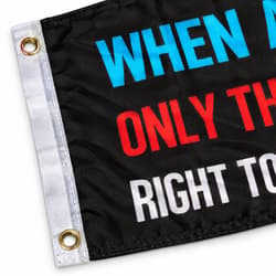Close-up of a black flag with colorful text and metal grommets