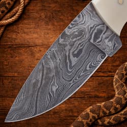 Close-up of Damascus steel blade on wooden background