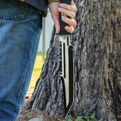 angled view of a "USMC" sawback knife with serations on both edges of the blade and a sturdy handguard.