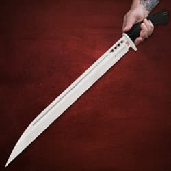 Hand holding Honshu D2 knife with black handle on red background