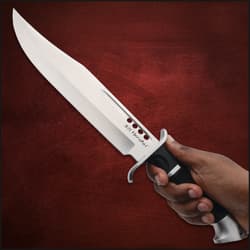 Hand holding a large knife with black handle
