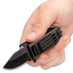 Hand holding pocket knife caddy with extended 2" black blade and exposed pocket clip.