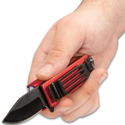 Hand holding pocket knife caddy with extended 2" black blade and exposed pocket clip.
