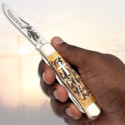Hand holding a pocket knife with cross design