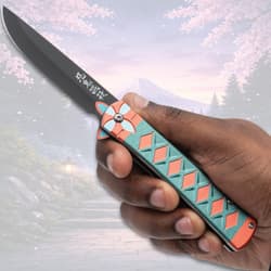 Hand holding a colorful folding knife outdoors
