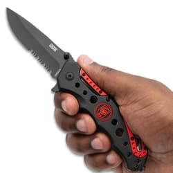 Hand holding a black and red folding knife