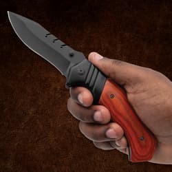 Hand holding a knife with a wooden handle