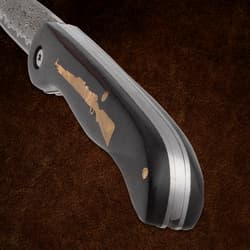 Close-up of knife handle with rifle inlay and blade edge