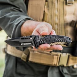Person holding a black tactical knife with USMC logo