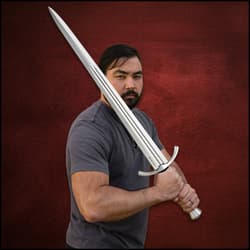 Person holding a broadsword against a red backdrop