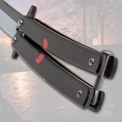Close-up of black butterfly knife handle with red design