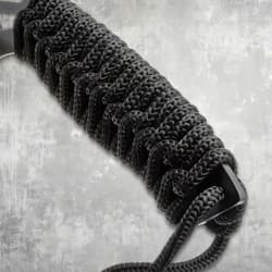 Close-up of black paracord-wrapped handle on a machete