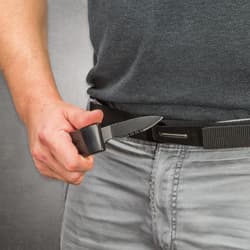 Person holding hidden knife from black belt