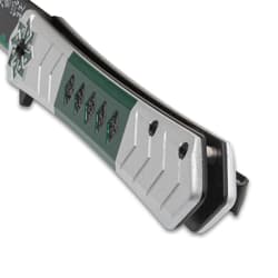 Close-up of knife handle with green and silver design