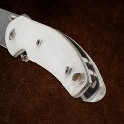 Close-up of white knife handle with screws on brown background