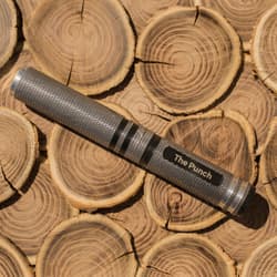 Metal punch tool on stacked wooden logs