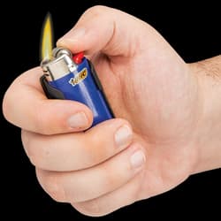 Hand holding black pocket knife lighter caddy containing blue "BIC" lighter that has been lit by the hand's thumb.