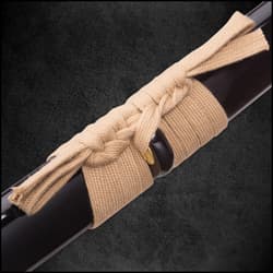 Zoomed top view of japanese samurai sword hilt with small peek of tan cord wrapped around tsuka