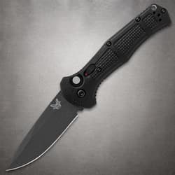 Black folding knife with textured handle on gray background