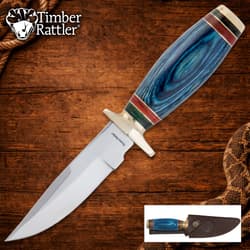 Knife with blue pakkawood handle on wooden background