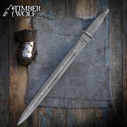 Sword on chainmail with gauntlet on wooden surface