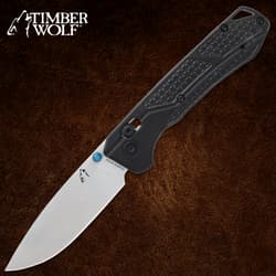 Black-handled folding knife with a silver blade on a brown background