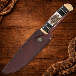 Knife in leather sheath on wooden surface with rope