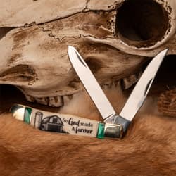 Open pocket knife with farm-themed handle, placed on fur