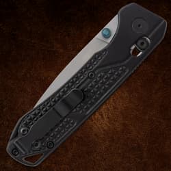 Closed folding knife with textured black handle and pocket clip