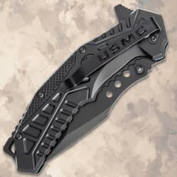 Closed black tactical knife with USMC branding