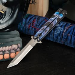 Butterfly knife with dragon design on a blue fabric