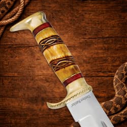 Close-up of the knife's ornate handle on wooden background