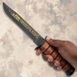 Hand holding a commemorative knife with leather handle