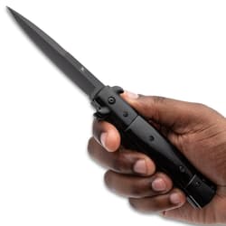 Hand holding a black stiletto knife with a sharp blade