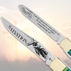 Two open blades of a pocket knife with religious etchings